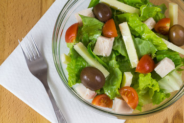 Bowl of fresh vegetable salad served on a wooden table