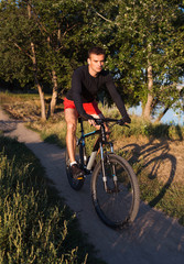 Fototapeta na wymiar Mountain bike cyclist riding at sunrise healthy lifestyle doing