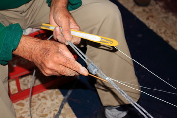 pescatore intento alla riparazione della rete da pesca