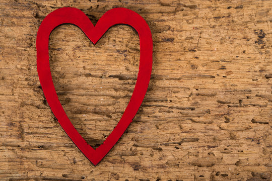 red heart frame on wooden surface