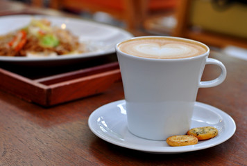 Close up coffee latte art with biscuits on the table.