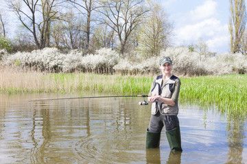 woman fishing in pond in spring