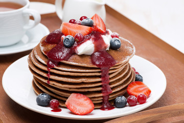 pancakes with cream, fruit sauce and fresh berries