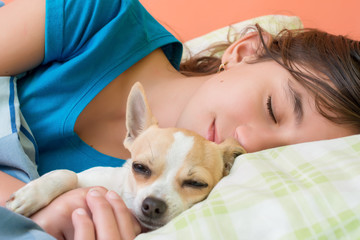 Cute girl hugging and sleeping with her small dog