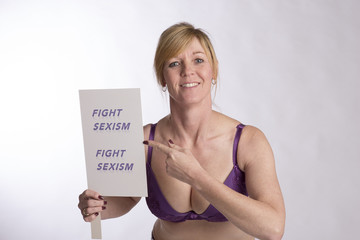 Mature female protester holding Fight Sexism poster