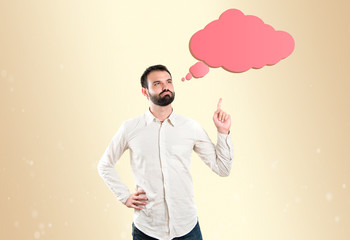 Young man pointing up and thinking over white background