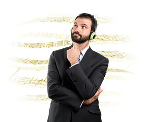 Young businessman listening music over white background