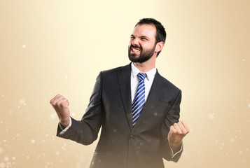 Young business man winner over abstract brown background