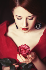 Fototapeta na wymiar Beautiful redhead women with rose.