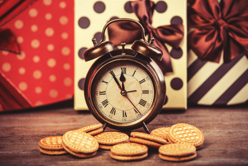 Retro alarm clock with cookie on a table.