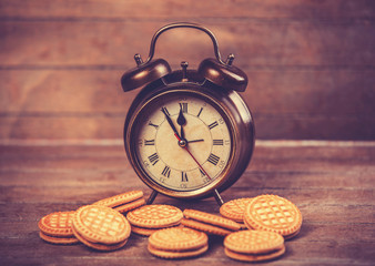 Retro alarm clock with cookie on a table