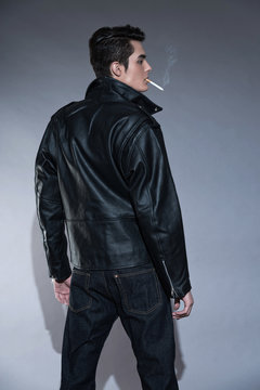 Retro rock and roll 50s fashion man with dark grease hair. Smoki