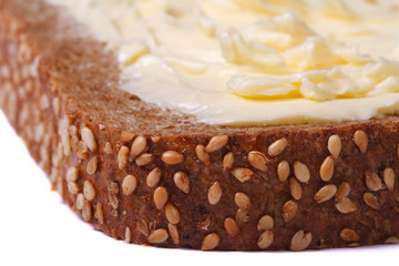 bread with sesame seeds and butter close up isolated