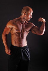 Fototapeta na wymiar Muscular bodybuilder flexing biceps