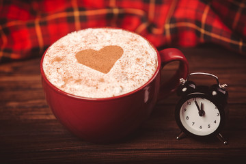 Cup of coffee and little black alarm clock