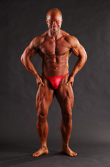 Fototapeta na wymiar Muscular male bodybuilder posing in studio