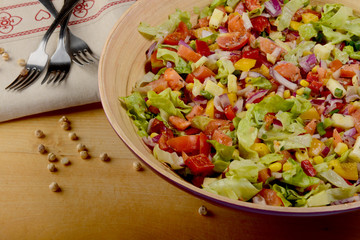 Big wooden bowl of fresh vegetable salad