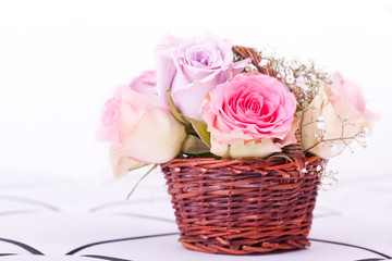 pink roses in brown basket of withe background
