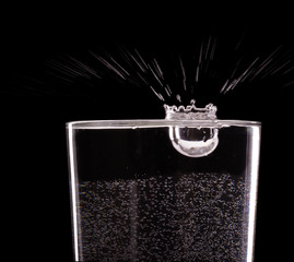 Pouring water into glass on black  background