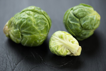 Fototapeta premium Close-up of brussels sprouts over black wooden surface