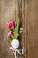 Spring flowers in easter egg shell on rough wooden background