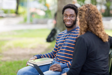 Male Student Sitting With Female Friend On Campus
