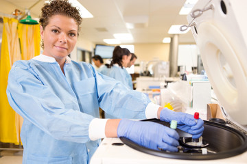 Obraz premium Pretty Lab Tech Loading Centrifuge