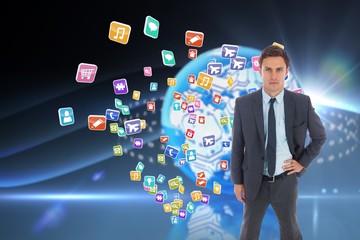 Composite image of stern businessman standing with hand on hip