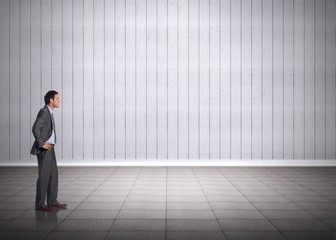 Fototapeta premium Composite image of smiling businessman with hands on hips