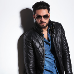 dramatic man in leather jacket and sunglasses posing