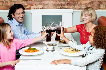 Family raising their glasses before eating