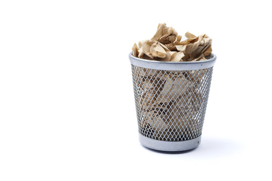 Iron trash bin full of paper, isolated on white background