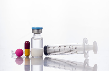Syringe with red medicine and bottle