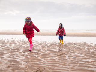 small boy and girl paddling on the beach