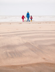 woman and two small children on winter beach