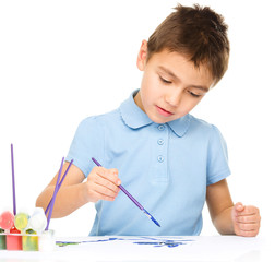 Boy is playing with paints