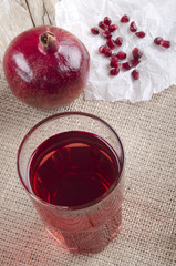 pomegranate juice in a glass on jute