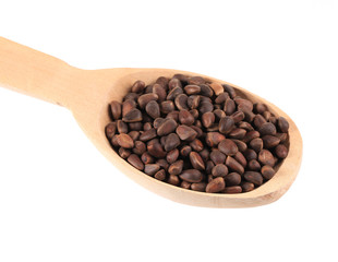 Wooden spoon full with pine nuts.