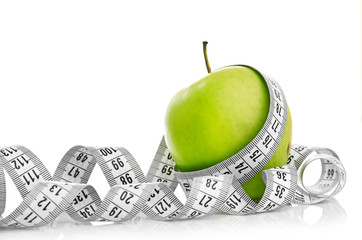 Measuring tape wrapped around a green apple