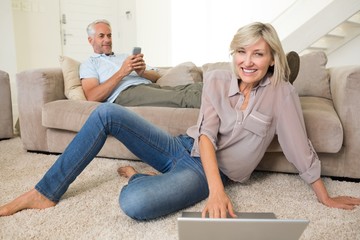 Couple with laptop and cellphone in living room at home
