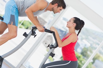 Determined couple working out at spinning class