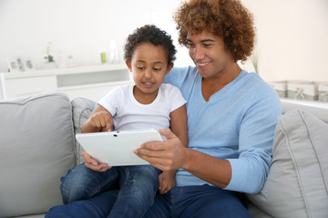 Father and child playing with digital tablet