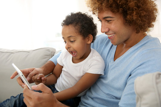 Father and child playing with digital tablet