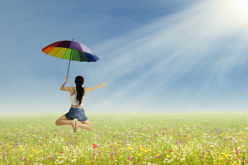 A girl jumping with umbrella