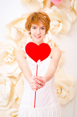 girl in white dress with red heart in hands