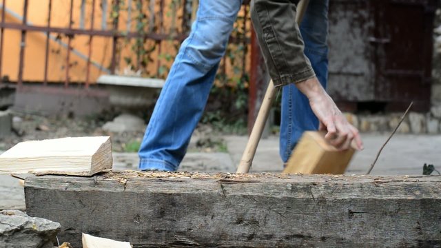 Lumber jack man chopping wood logs with ax. Making firewood