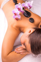 woman in spa salon with hot stones