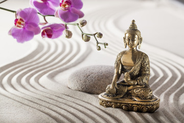Buddha in zen flower garden with smooth grooves in sand