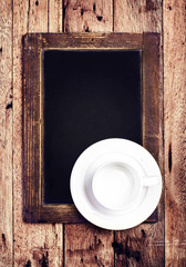 Obraz na płótnie Canvas Empty white Coffee cup on vintage blackboard. Blank slate chal