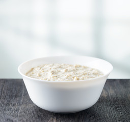 Bowl of oat porridge on wooden table